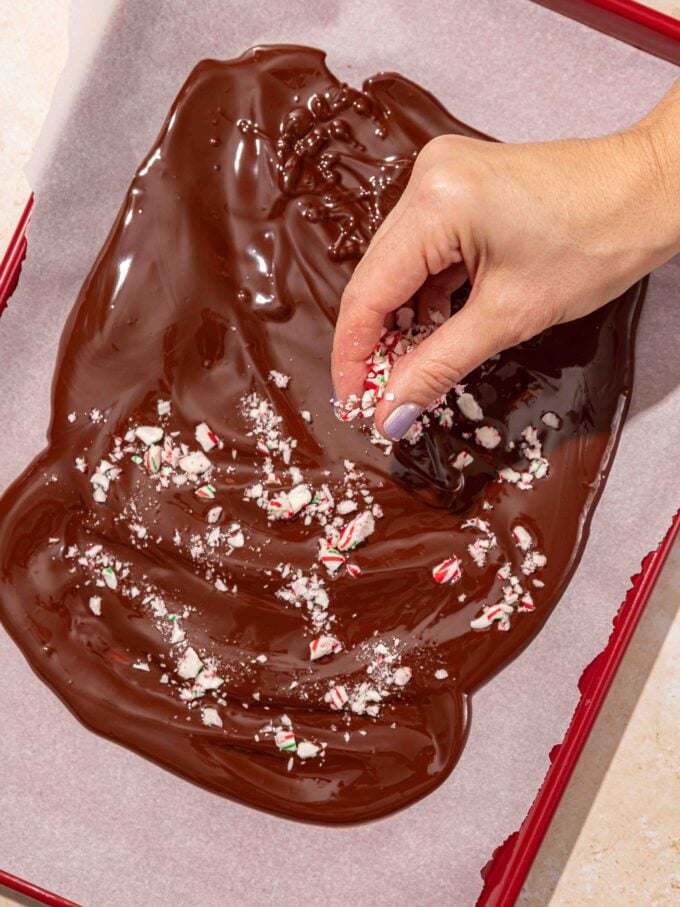 hand sprinkling candy over chocolate