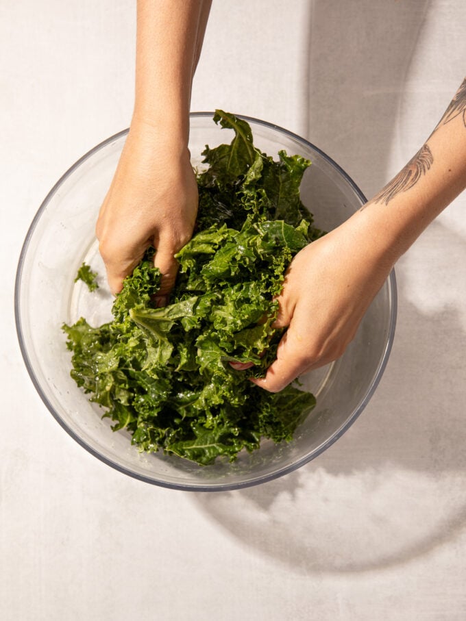 hands massaging kale