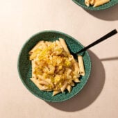 leeks and pasta in blue bowls with black spoon